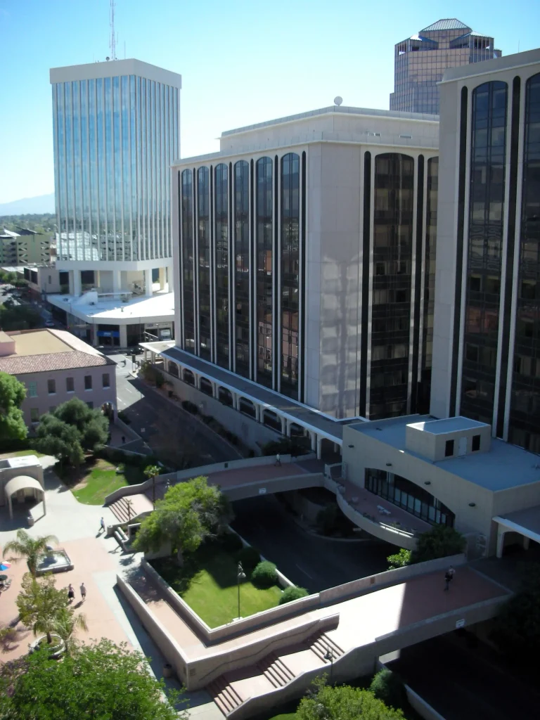 Downtown Tucson, Arizona, featuring office buildings, landscaped plazas, and pedestrian walkways under a clear blue sky.